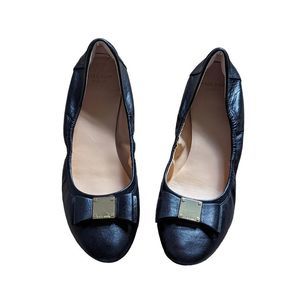 Cole Haan grand OS black flats with a gold label buckle in front size 9AA